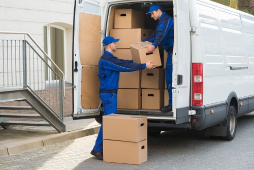 Mover wearing PPE while carrying furniture in Hackney