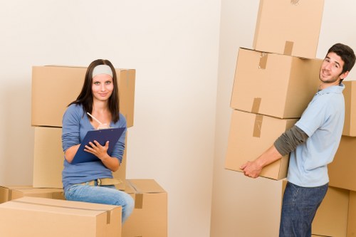 Local office removals team handling desks and equipment in an East London workspace